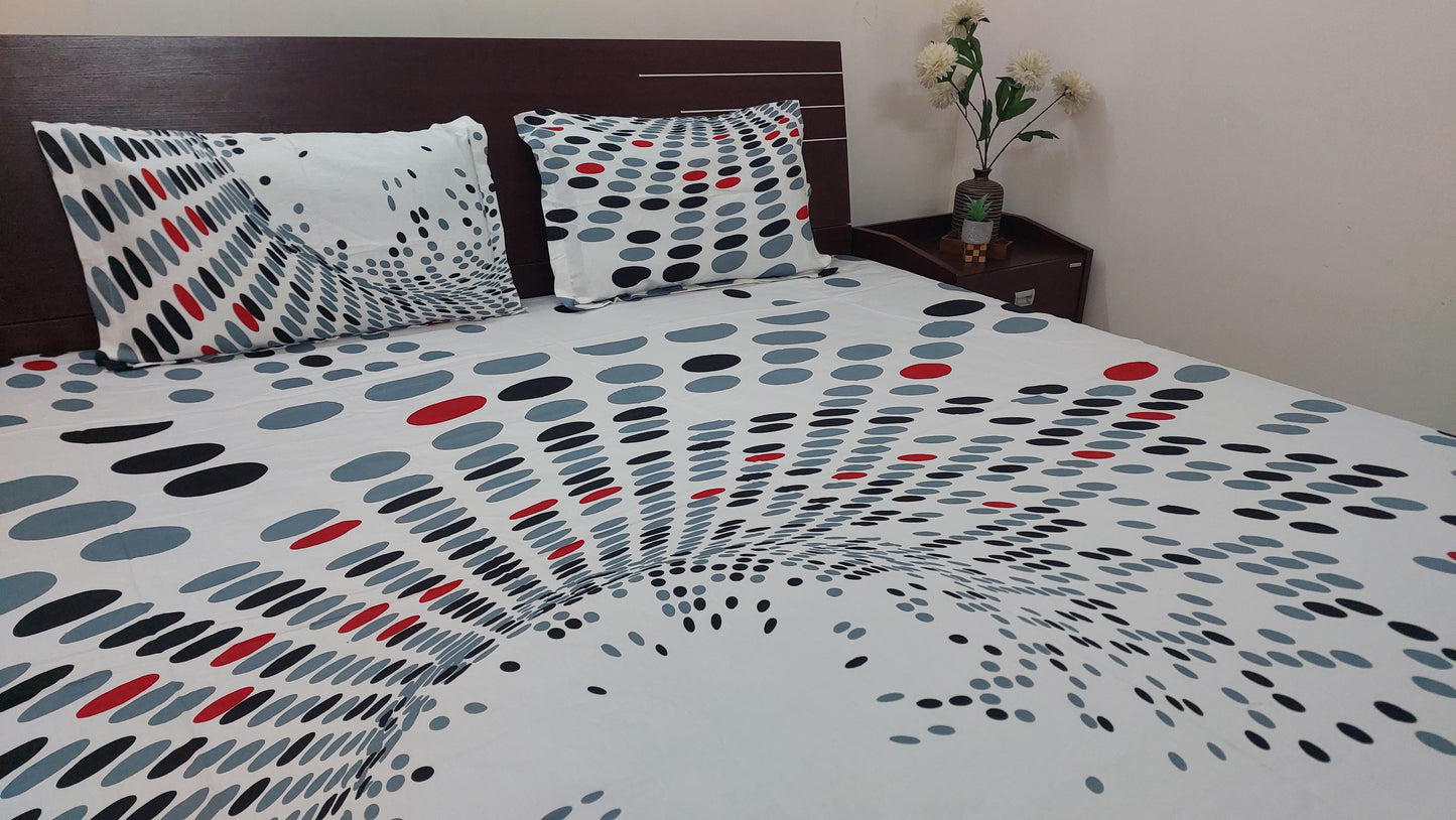 Polka dot bedspread with pillows on a bed in a bedroom setting.