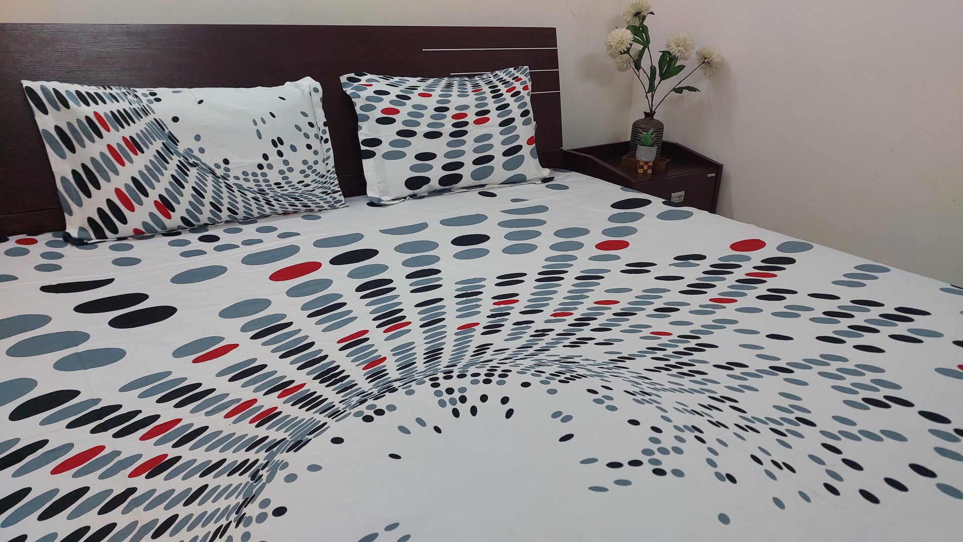 Polka dot bedspread with pillows on a bed in a bedroom setting.
