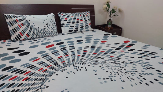 Polka dot bedspread with pillows on a bed in a bedroom setting.